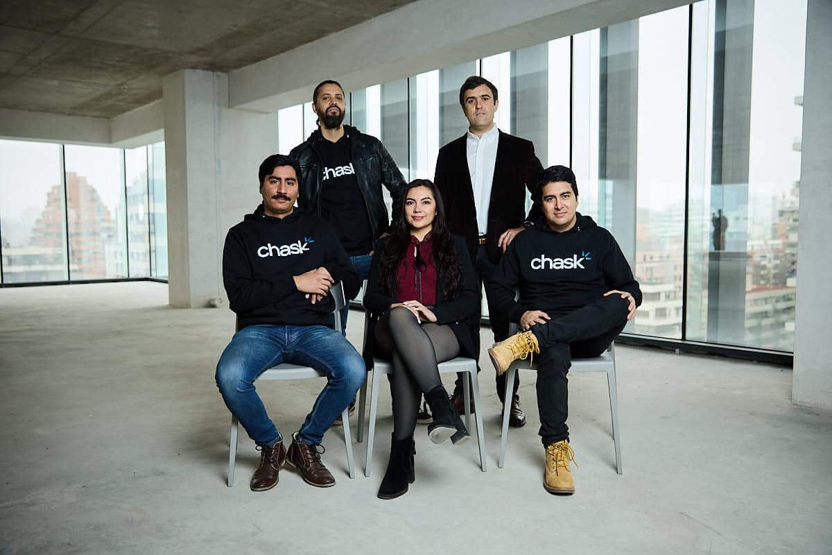 The Chask team, five people in Chask sweatshirts and jackets, in an open office floor in Santiago